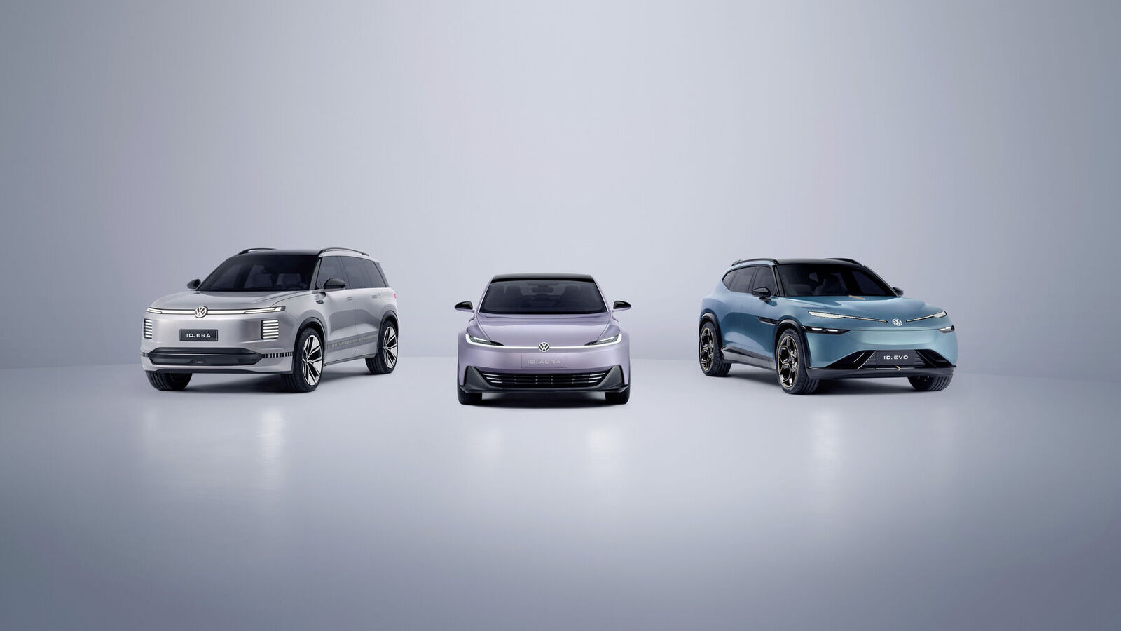 Drei Volkswagen Elektrofahrzeuge der ID-Serie stehen nebeneinander: ein silberner SUV (ID. ERA), ein lila Kompaktwagen (ID. AURA) und ein blauer SUV (ID. EVO).